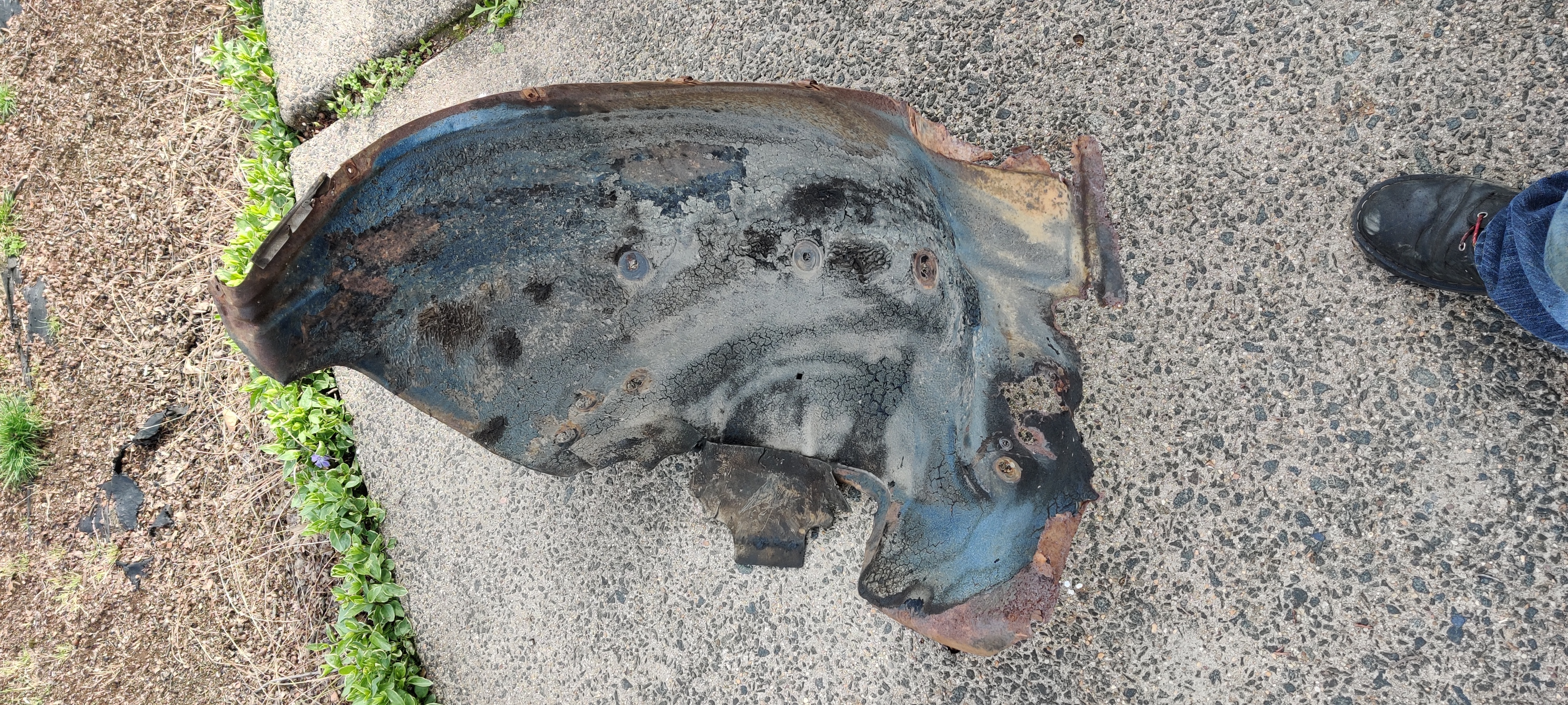 Old rusted out front right wheel well